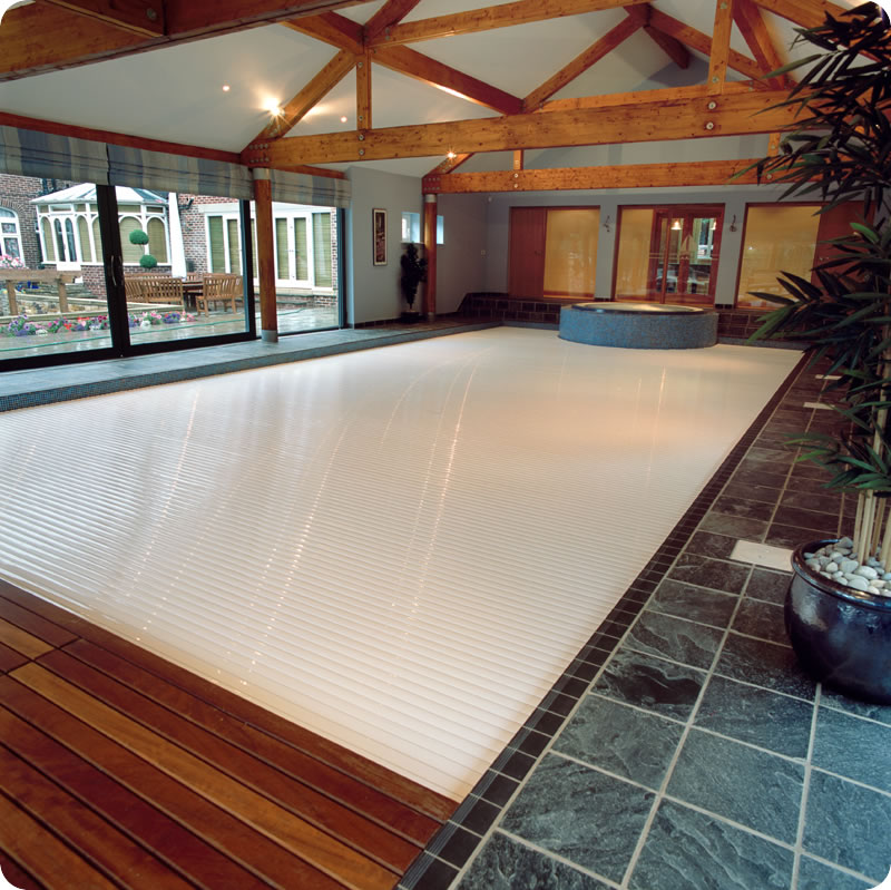 Automated swimming pool cover, covering a swimming pool